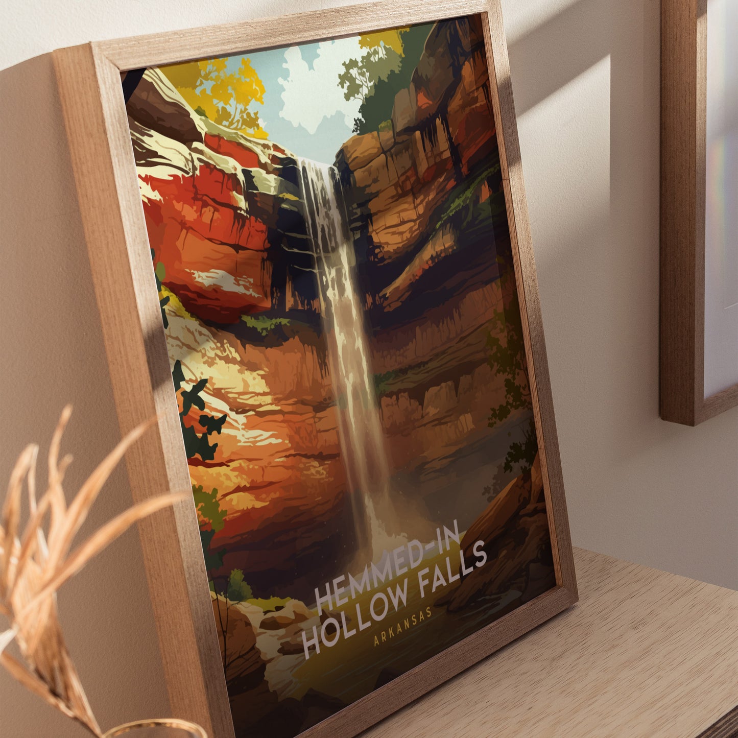 A framed poster of Hemmed-In Hollow Falls showcases a vibrant waterfall cascading down a rocky cliff surrounded by lush greenery. The artwork features warm colors and a serene atmosphere, highlighting the natural beauty of Arkansas.