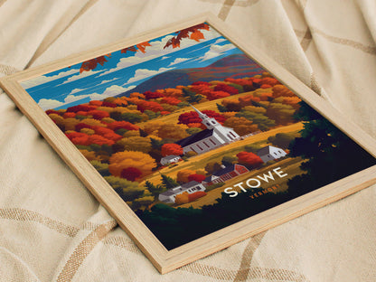 A framed poster of Stowe, Vermont, showcases a white church steeple amidst vibrant autumn foliage, with red, orange, and gold trees under a blue sky.