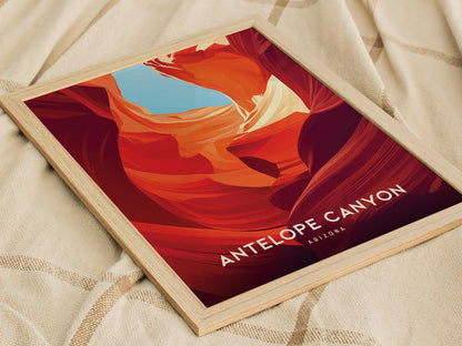 A framed poster of Antelope Canyon with vibrant red and orange sandstone formations against a blue sky, placed on a textured beige fabric.