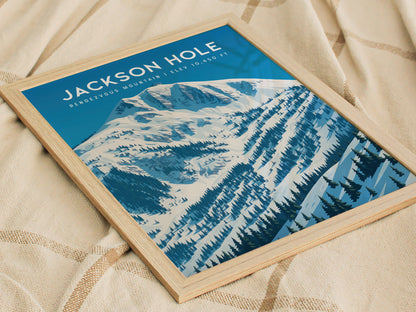 A framed poster titled Jackson Hole showcases a stunning winter landscape featuring snow-covered mountains and evergreen trees.