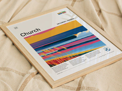 A framed poster titled Church features a vibrant illustration of a surf break, showcasing colorful waves and coastal scenery. The poster includes text about the location, San Clemente, California, and is placed on a textured fabric surface.