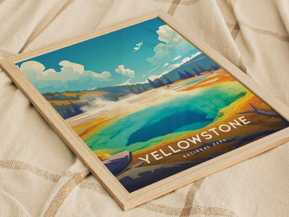 A framed poster of Yellowstone National Parks Morning Glory Pool, showcasing vibrant blue, green, and golden hues, rests on a textured beige fabric.