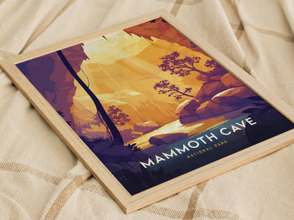 A framed poster of Mammoth Cave National Park featuring stylized illustrations of trees and rock formations in warm tones, resting on a textured fabric surface.