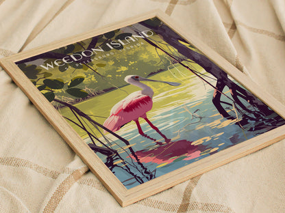 Framed poster depicting a vibrant pink Roseate Spoonbill wading through serene mangrove waters, set against a lush green background. The artwork rests on a textured beige fabric.