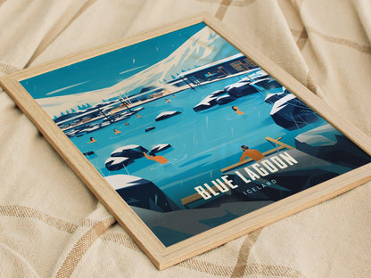 Framed poster of Blue Lagoon, Iceland, featuring people in milky blue geothermal waters surrounded by black lava rocks and snow-capped mountains, resting on a beige fabric background.
