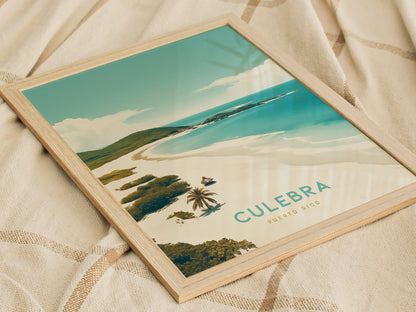 A framed poster featuring a scenic view of Culebra, Puerto Rico, with turquoise waters and sandy beaches, rests on a textured beige fabric.
