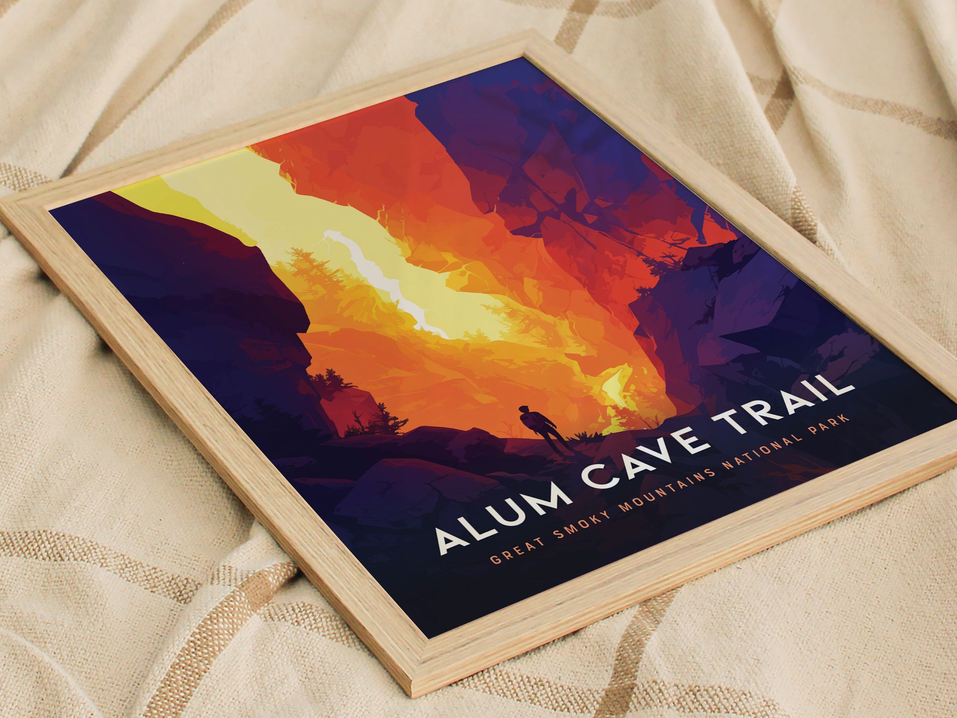 A vibrant poster featuring a hiker silhouette against a dramatic, colorful landscape of the Alum Cave Trail in the Great Smoky Mountains National Park, framed in light wood.