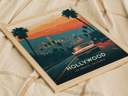 A framed Hollywood poster featuring a stylized view of Los Angeles with palm trees, a classic car, and a sunset skyline, placed on a beige textured surface.