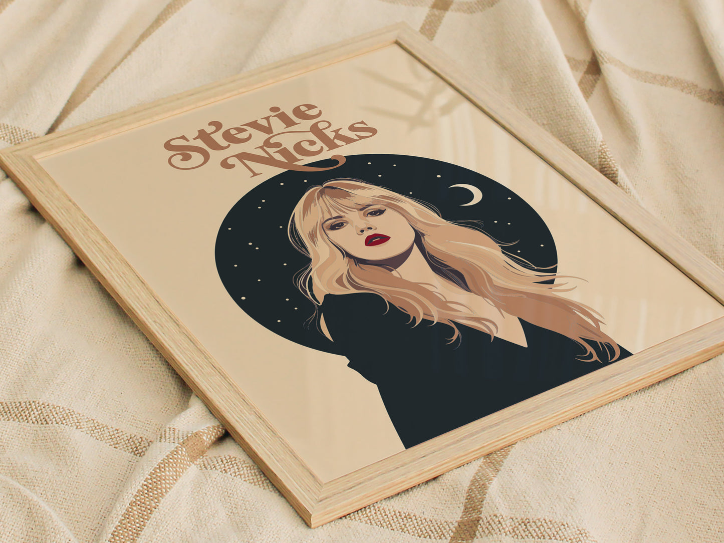 A framed poster featuring an illustration of a woman with long blonde hair against a dark celestial background, including stars and a crescent moon, titled Stevie Nicks.