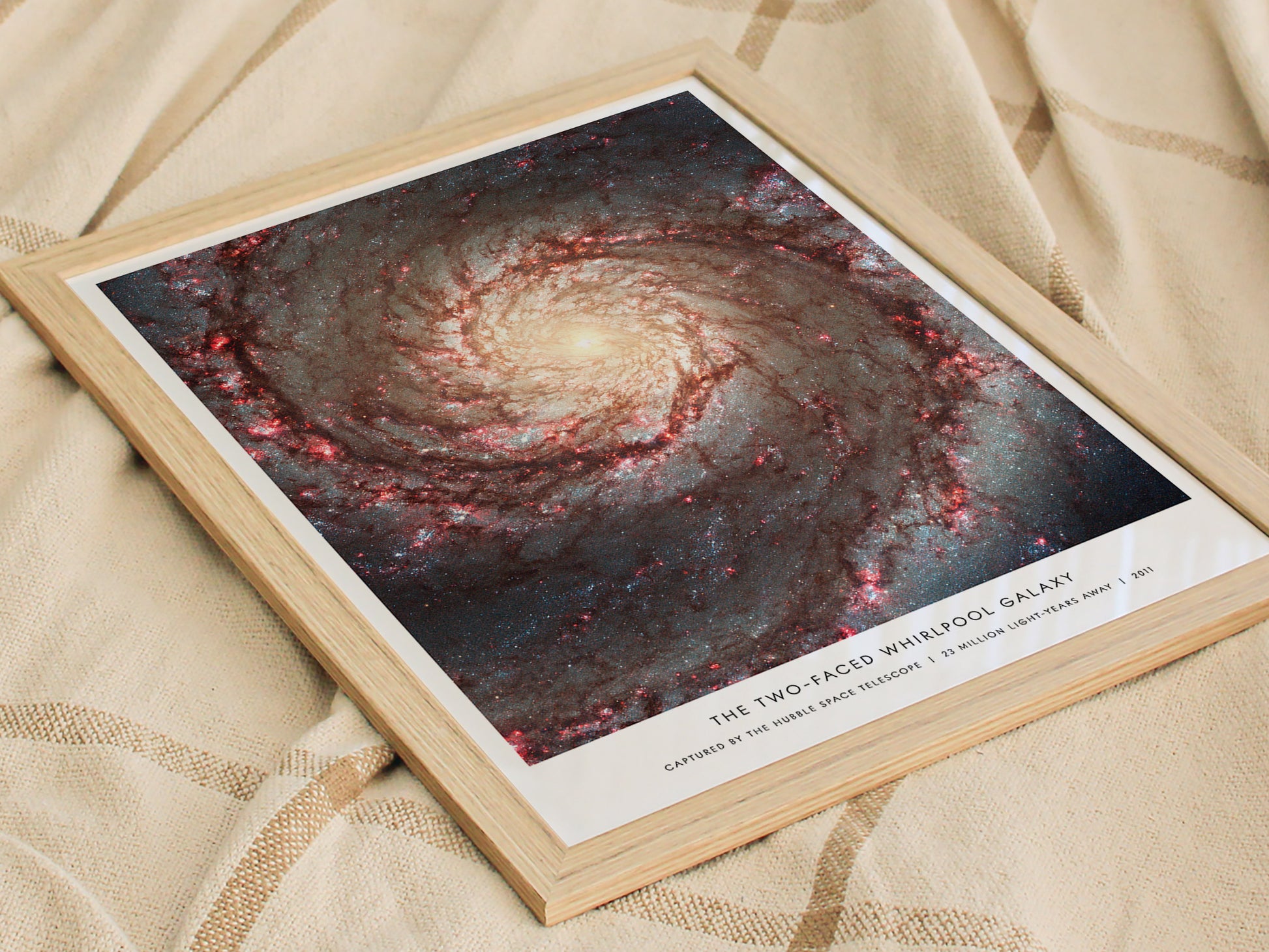 Framed print of the Two-Faced Whirlpool Galaxy on a textured surface