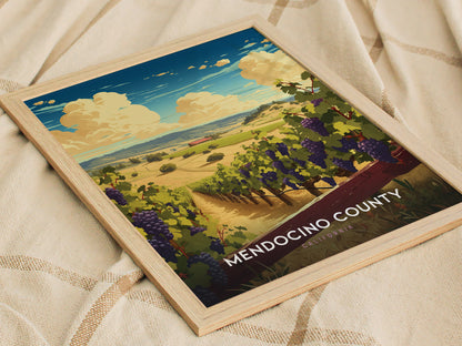 A framed poster of Mendocino County, California, featuring a scenic view of vineyards and rolling hills under a vibrant blue sky with fluffy clouds, resting on a textured fabric.