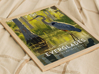 A framed art print featuring a Great Blue Heron wading in a lush Everglades landscape, with cypress trees and vibrant green foliage, titled Everglades Florida National Park.