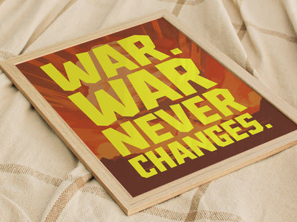 A framed poster with bold yellow text reading War. War Never Changes. against a background of muted reds and oranges, resting on a textured beige fabric.