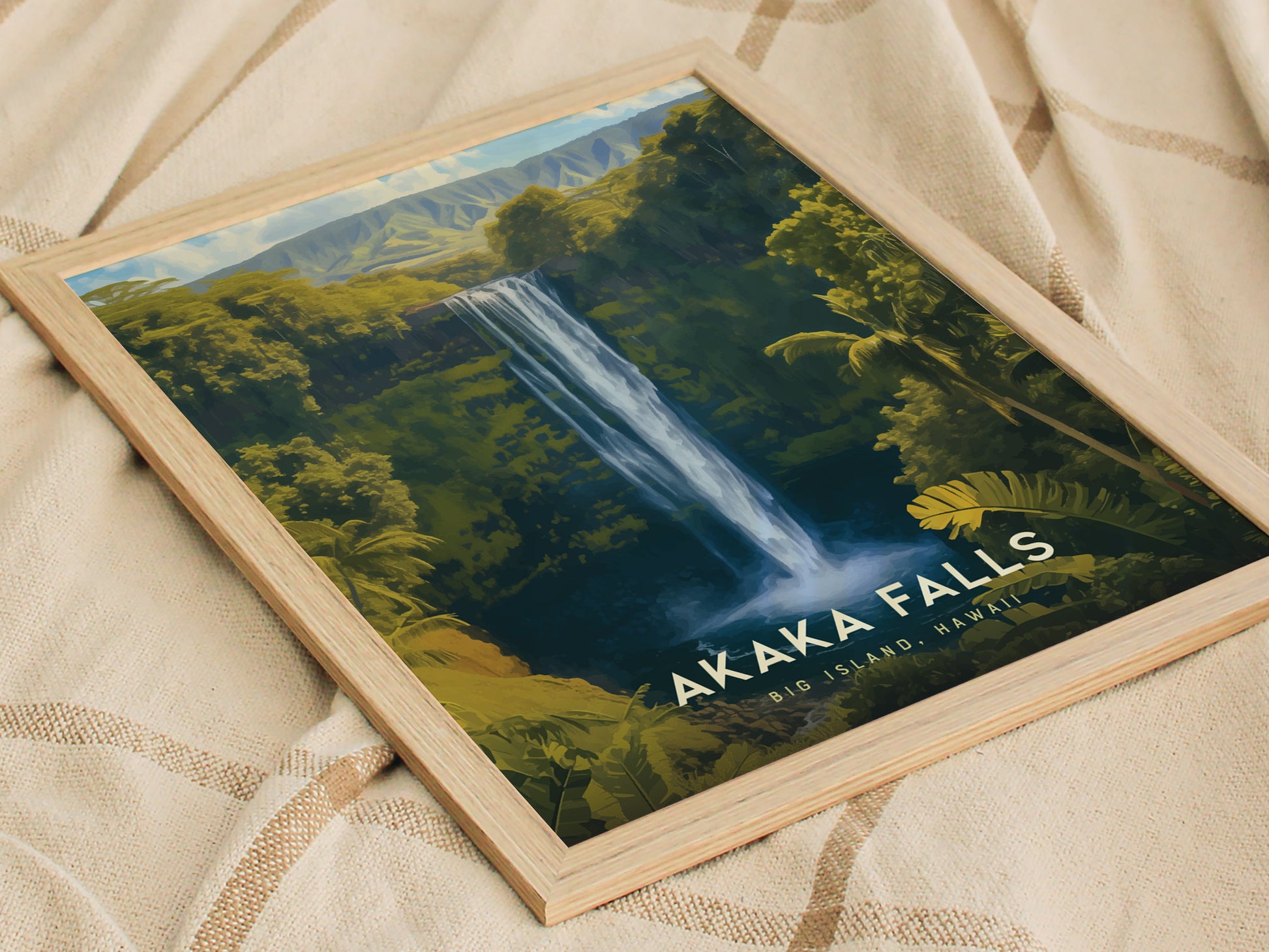 Framed Akaka Falls poster depicting a waterfall amid lush greenery on a beige fabric backdrop. The artwork highlights the scenic beauty of Big Island, Hawaii.