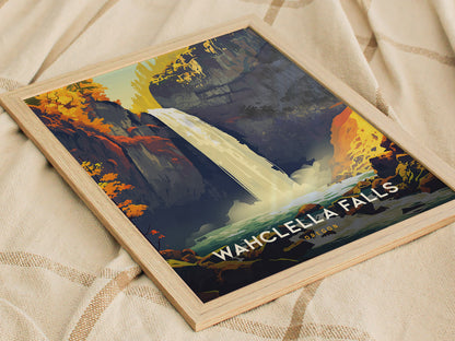 A framed poster of Wahclella Falls on a light fabric surface, featuring vibrant autumn foliage and a cascading waterfall in a scenic gorge.