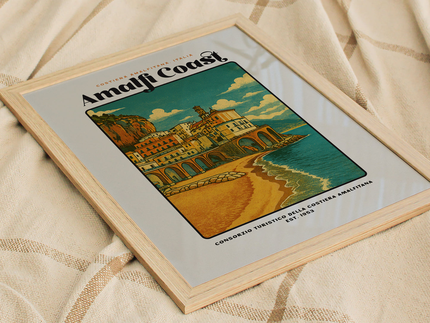 Framed artwork of the Amalfi Coast with a scenic illustration on a textured fabric background.