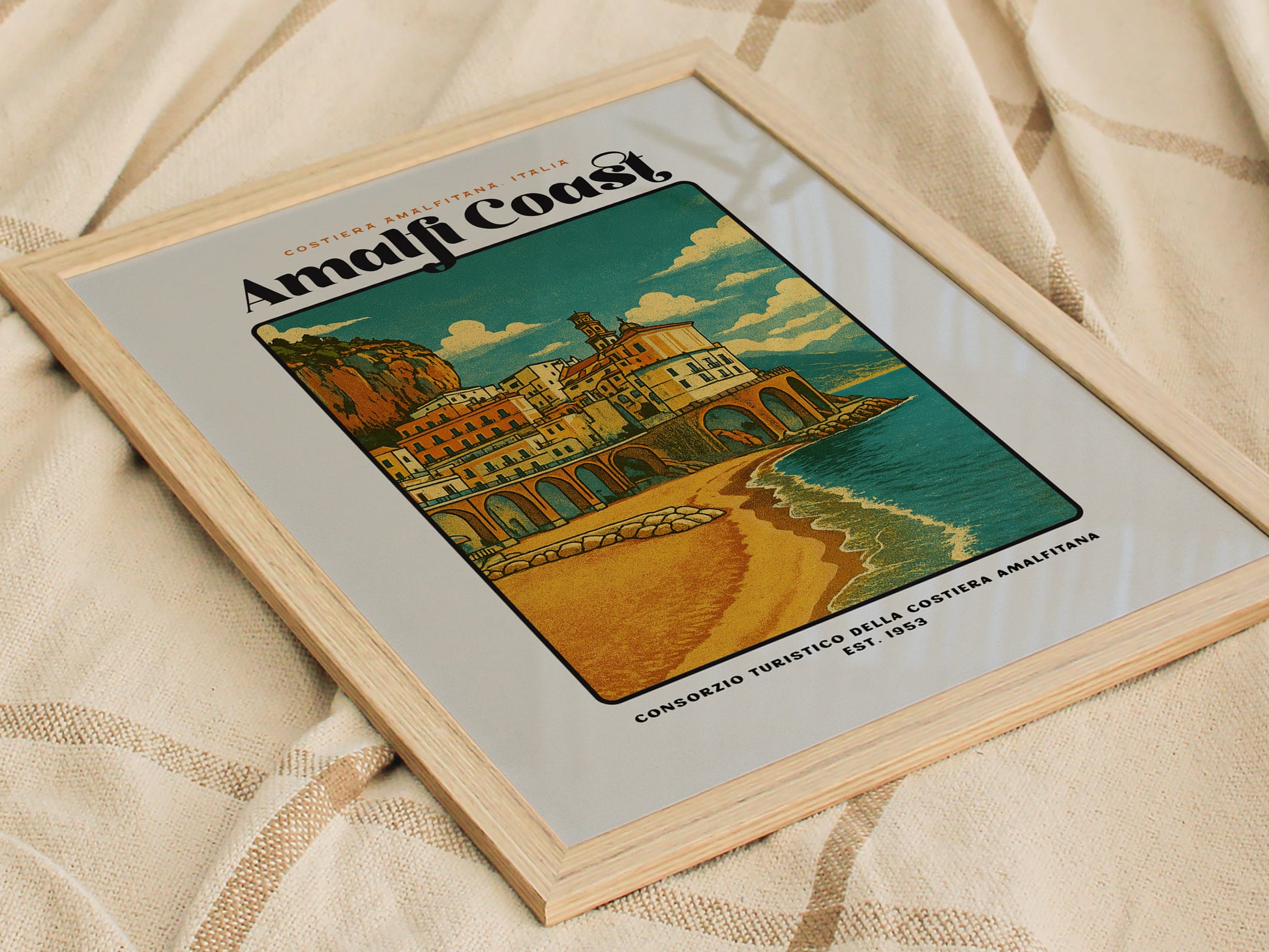 Framed artwork of the Amalfi Coast with a scenic illustration on a textured fabric background.