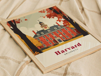Framed illustration of a red brick Harvard University building with a clock tower, surrounded by autumn trees. The poster rests on a beige fabric surface.