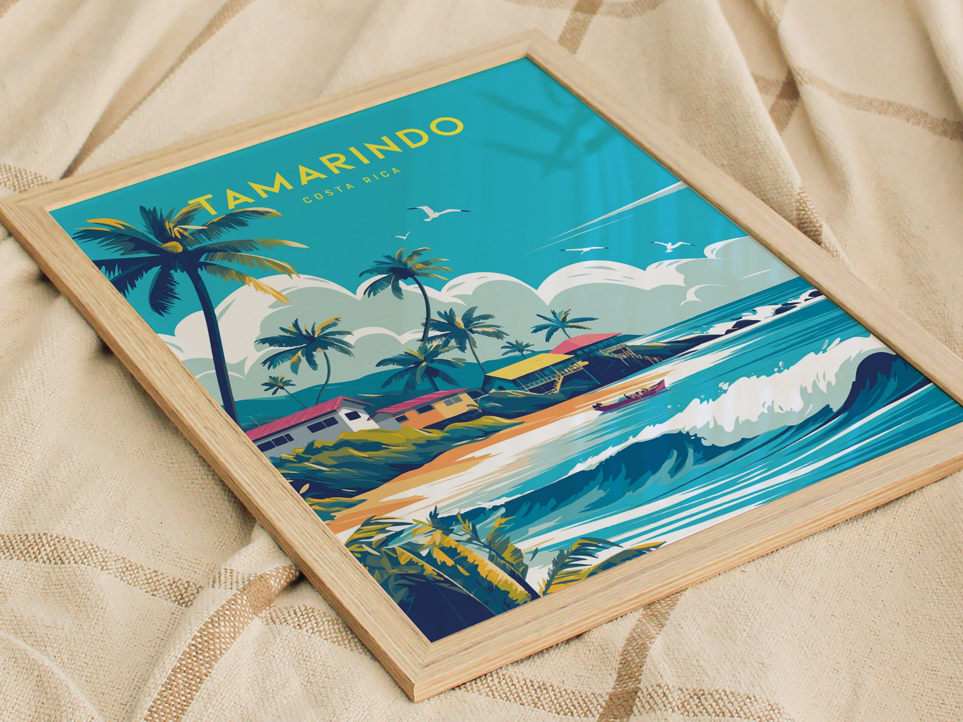 A framed poster featuring vibrant artwork of a coastal scene with waves, palm trees, and houses, set against a bright blue sky with seagulls flying.