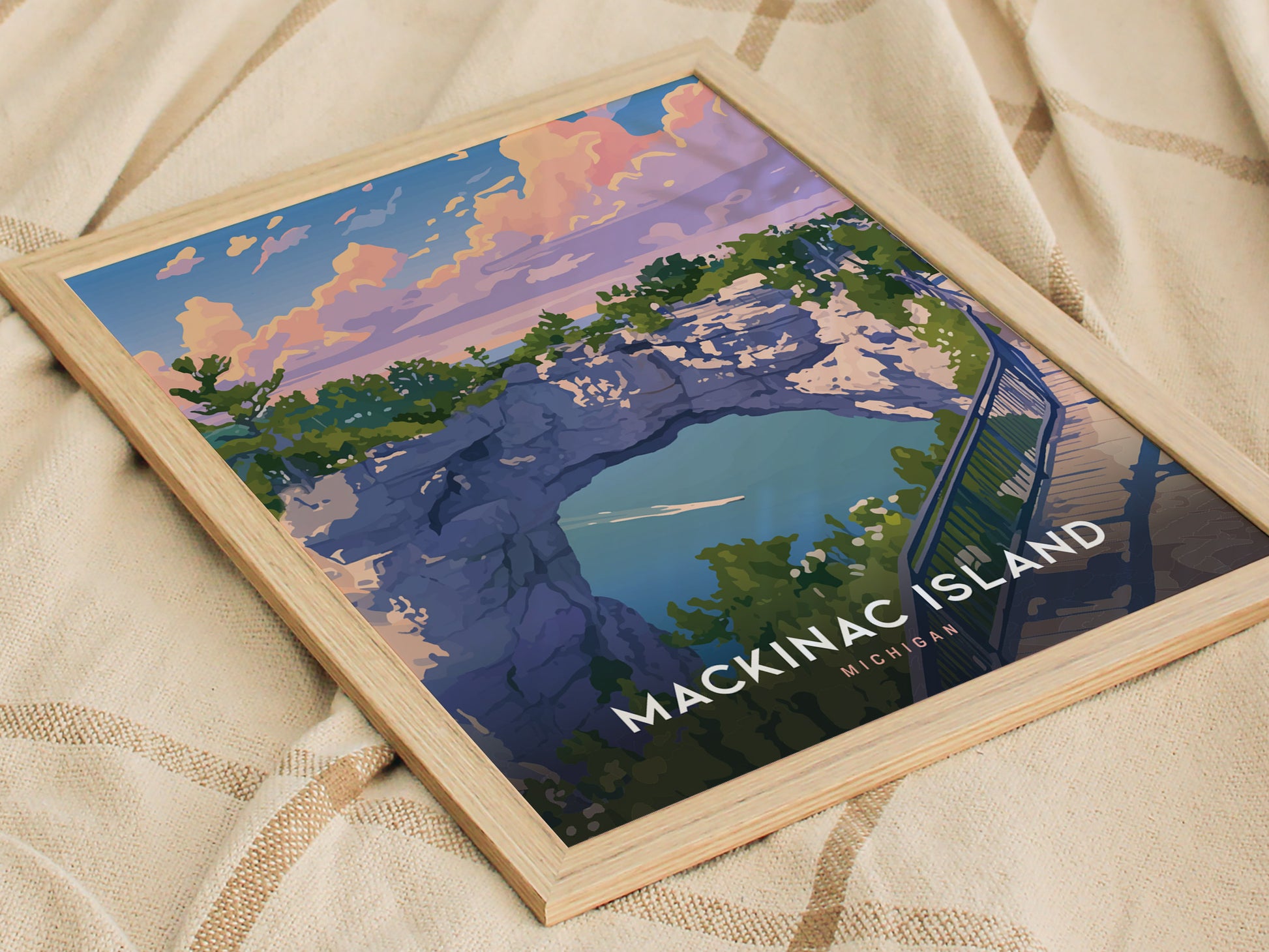 A framed poster of Mackinac Island Arch Rock features colorful artwork depicting a scenic view with a limestone arch, trees, and a vibrant sky. The text reads MACKINAC ISLAND, MICHIGAN.