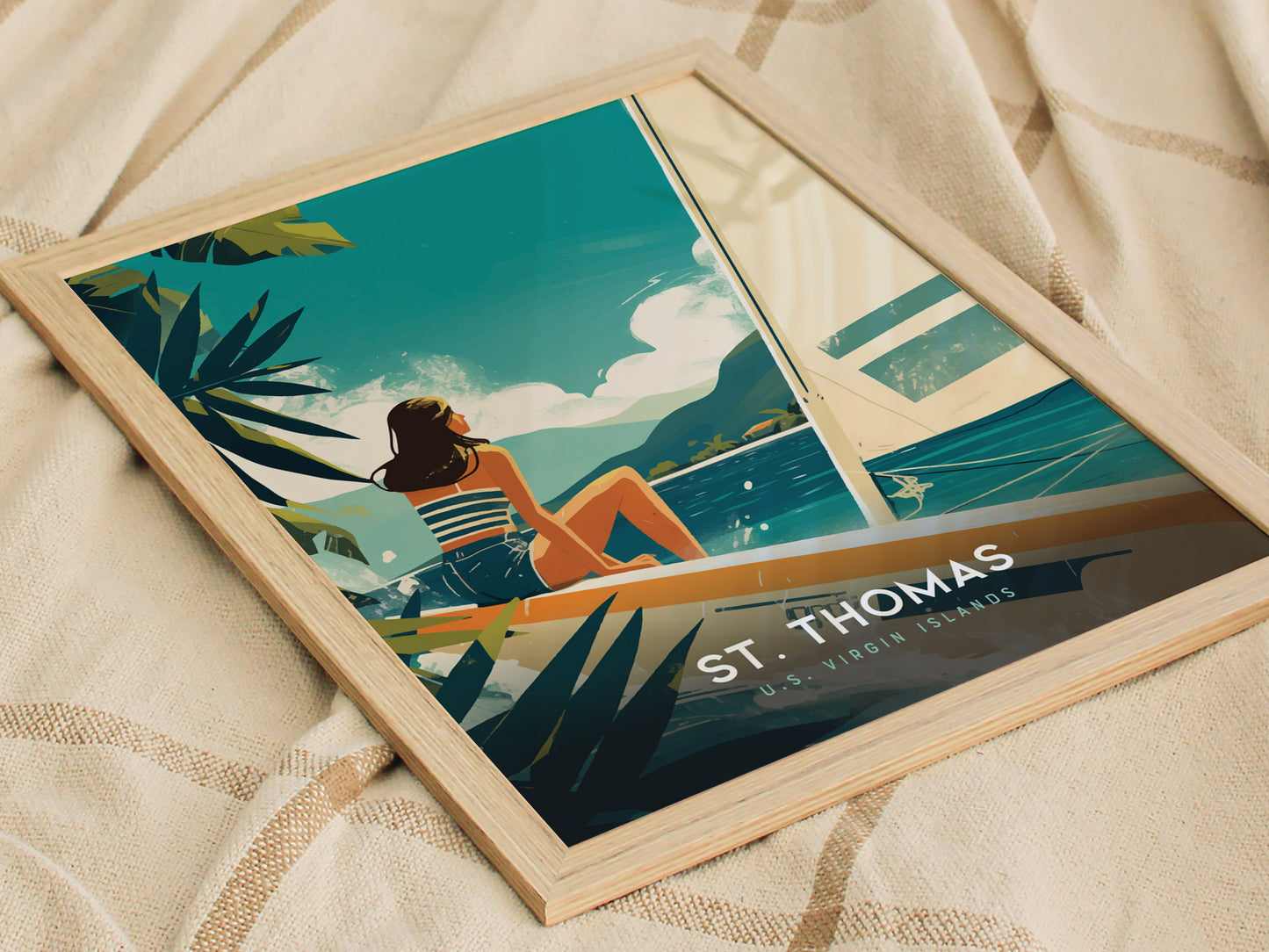 A framed poster depicting a woman in a striped outfit sitting on a sailboat with turquoise waters and lush greenery, titled St. Thomas U.S. Virgin Islands.