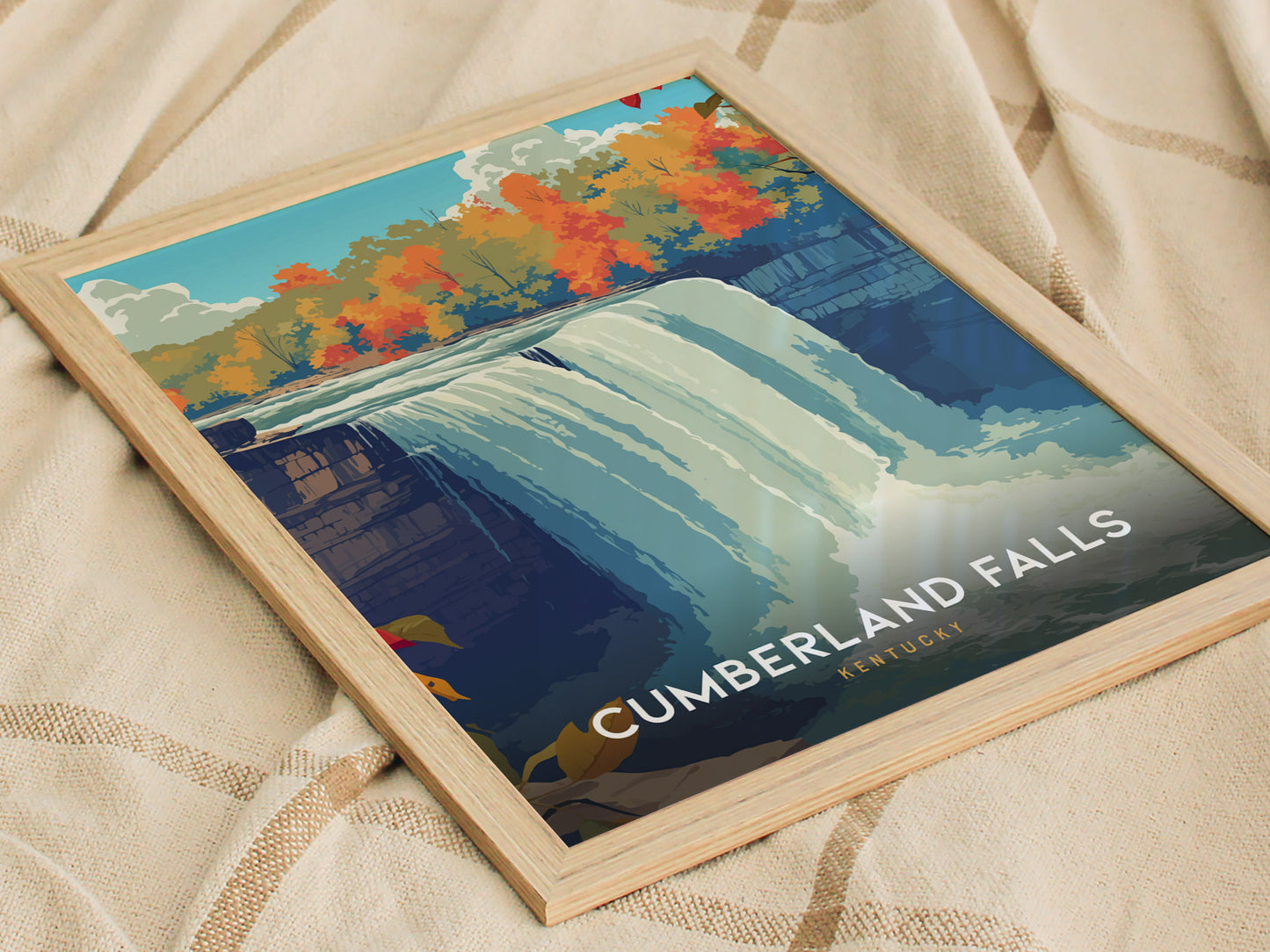 A framed poster of Cumberland Falls in Kentucky features a vibrant illustration of the waterfall surrounded by colorful autumn foliage. The artwork showcases the falls cascading water and highlights the natural beauty of the area.