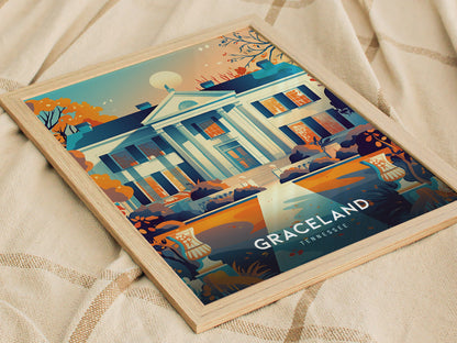 A framed poster depicting the iconic façade of Graceland, surrounded by vibrant autumn foliage, rests on a soft beige fabric. The text Graceland Tennessee is visible at the bottom.