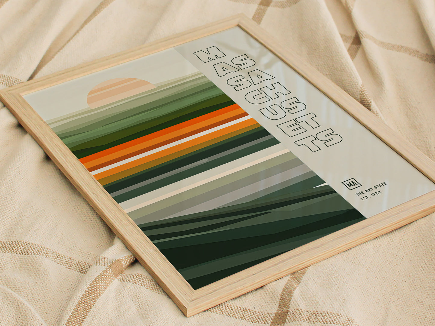 A framed Massachusetts poster featuring a minimalist design with horizontal green and orange stripes and a setting sun. The text Massachusetts appears vertically on the right.