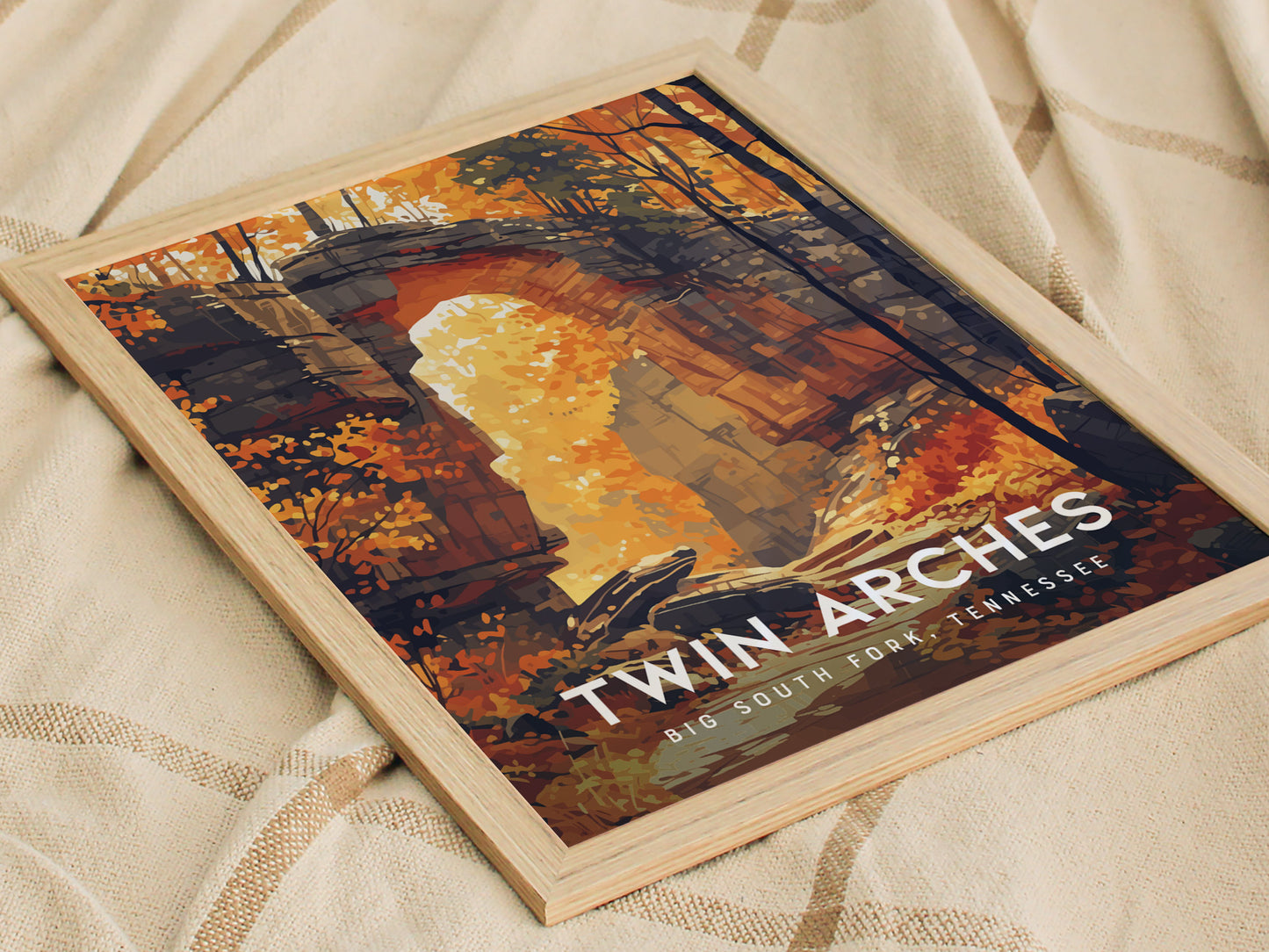 Framed poster of Twin Arches in Big South Fork, Tennessee, featuring vibrant autumn foliage and sandstone arches, displayed on a beige fabric surface.