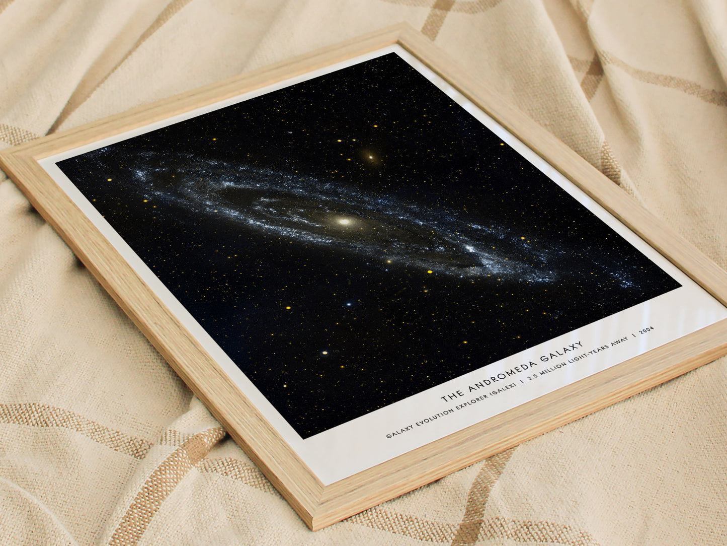 Framed print of 'The Andromeda Galaxy' on a textured fabric background