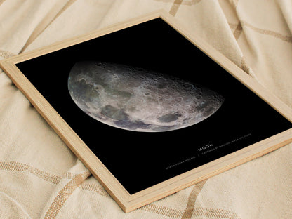 Natural wood framed Moon print leaning on a shelf next to plants and minimalist decor