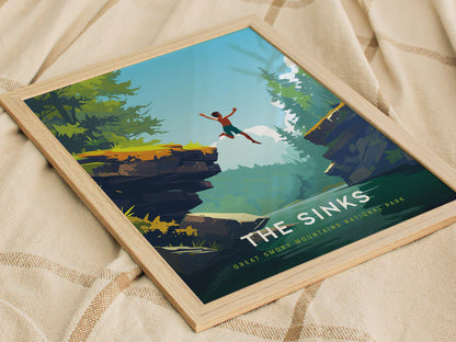 Framed artwork depicting a vibrant landscape in Great Smoky Mountains National Park, with a person leaping from a rocky ledge into a lush, forested backdrop. The text reads The Sinks at the bottom.