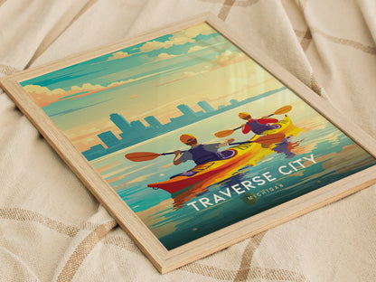 A framed Traverse City poster shows two kayakers paddling on a colorful, serene bay with a city skyline in the background, capturing the vibrant outdoor spirit.