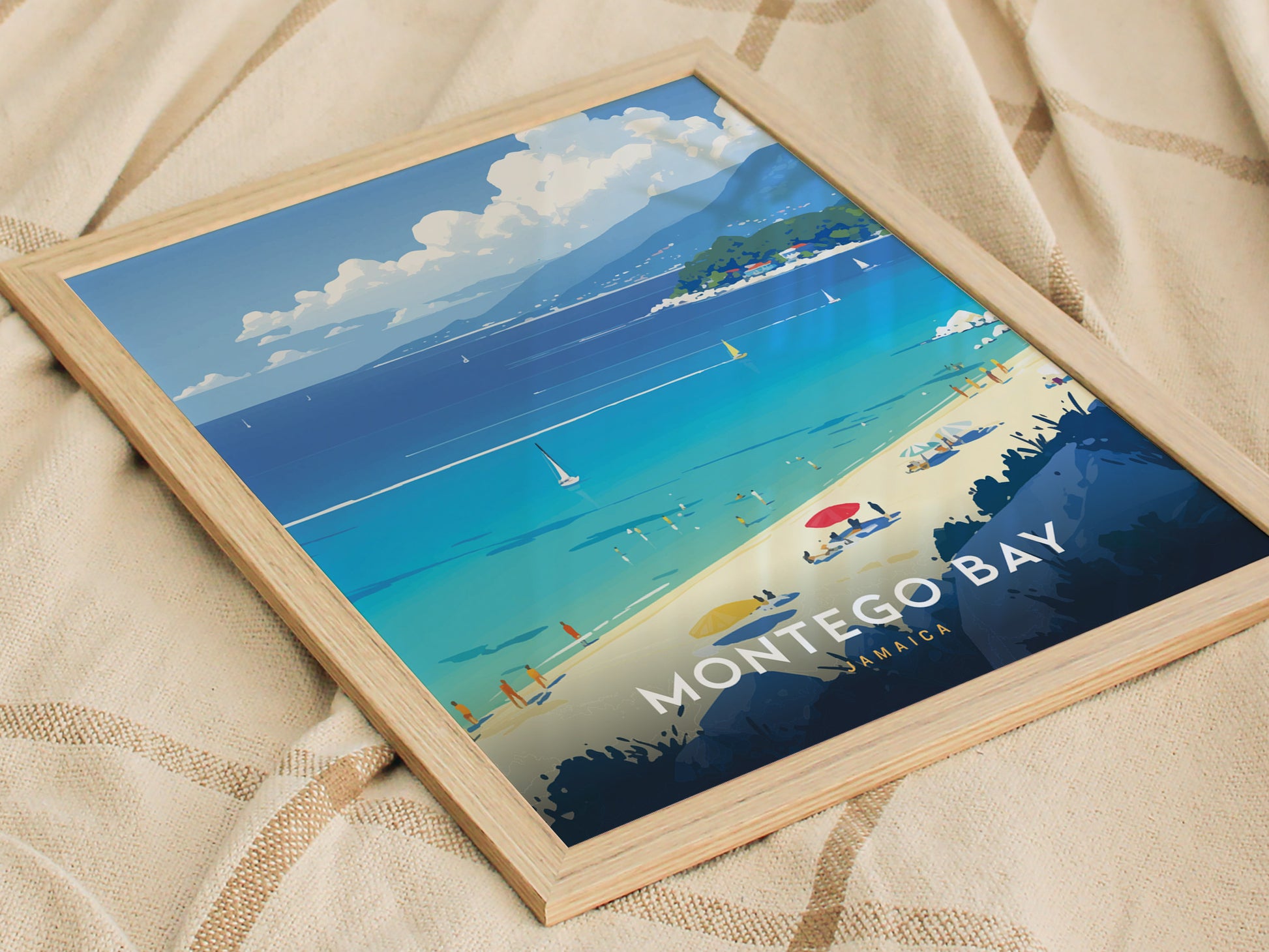 A framed poster of Montego Bay, Jamaica, depicts a vibrant beach scene with turquoise water, sailboats, and people lounging under colorful umbrellas, set against a mountainous backdrop.
