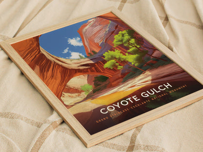 Framed poster depicting Coyote Gulch with vibrant red canyon walls and vivid green trees, set against a bright blue sky. The text reads Coyote Gulch, Grand Staircase-Escalante National Monument.
