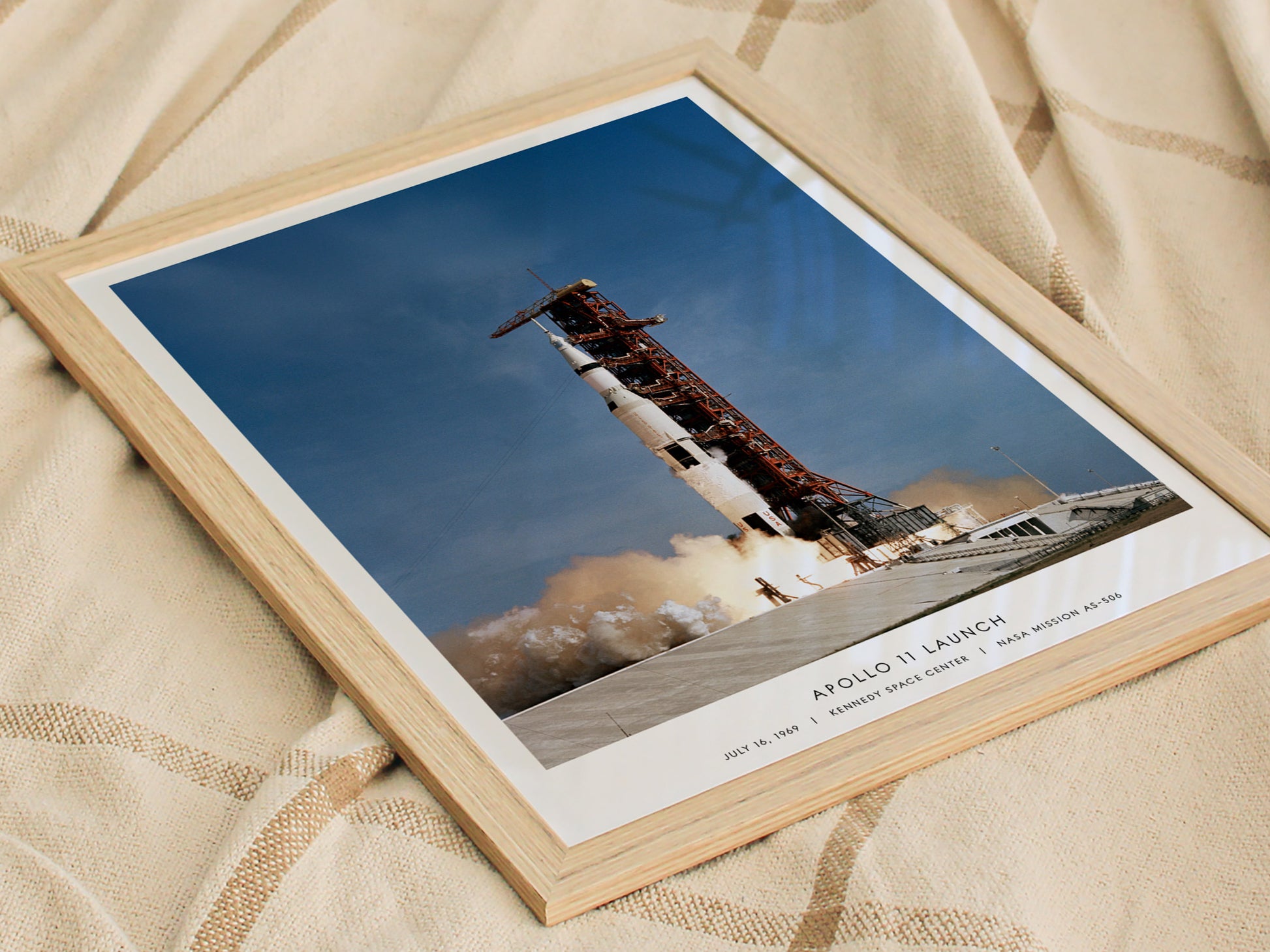 Framed print of an Apollo 11 launch on a textured fabric background