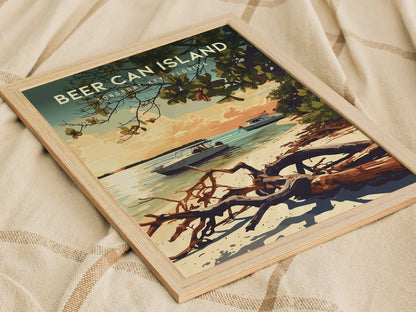 A framed poster of Beer Can Island, Longboat Key, features a serene beach scene with boats on turquoise waters, driftwood lining the shore, and a tree branch extending into the image. The artwork rests on a textured fabric surface.