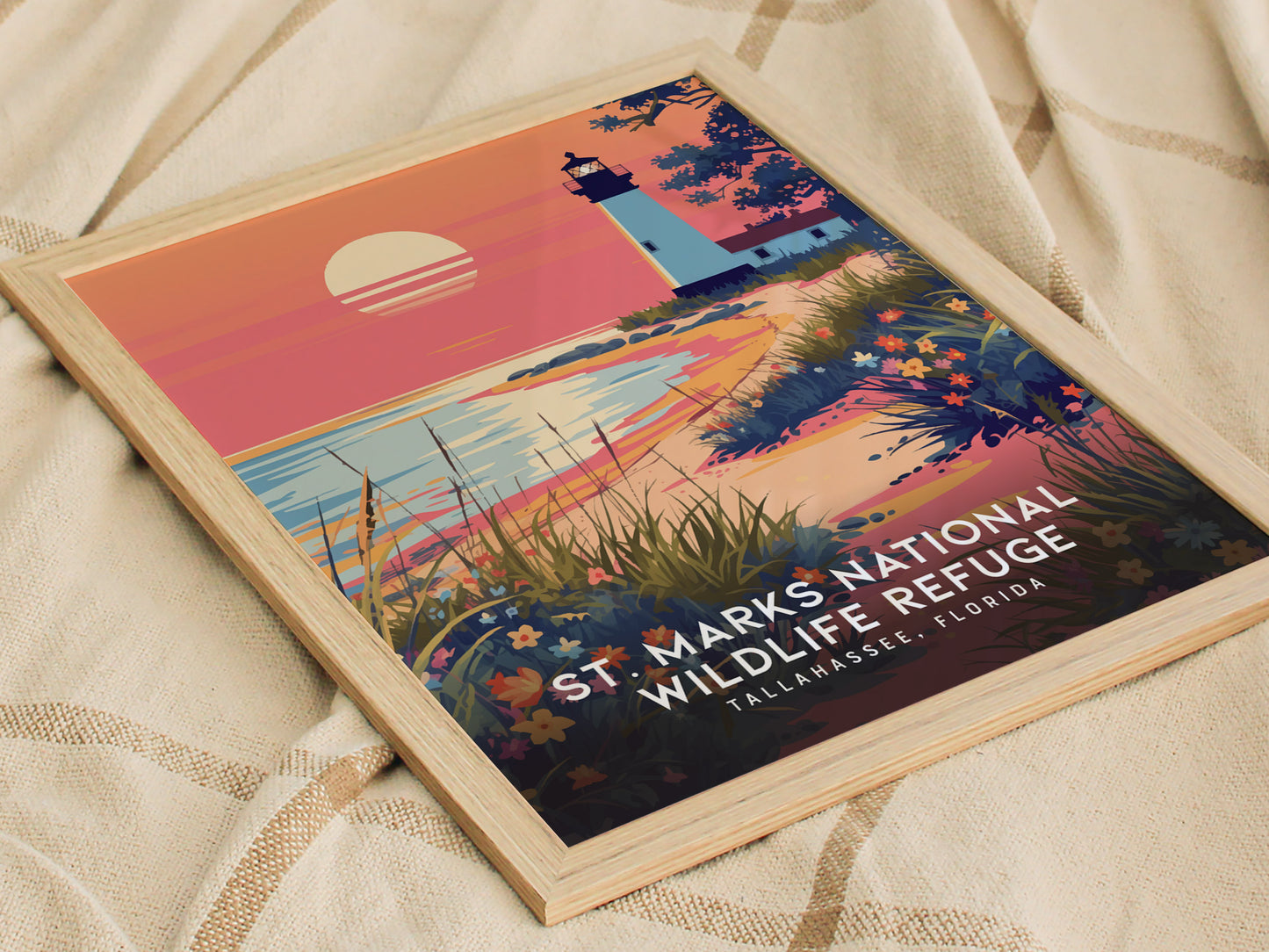 A framed poster of St. Marks National Wildlife Refuge features a lighthouse against a vibrant sunset, surrounded by wildflowers and coastal marshes. Text reads Tallahassee, Florida.