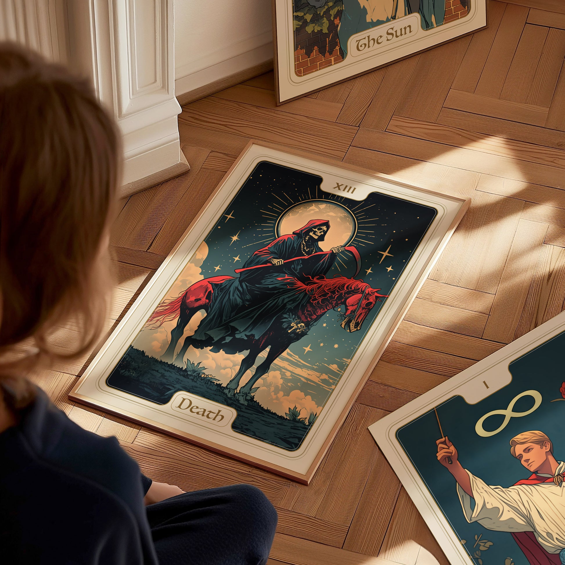 A person observes a tarot poster on the floor featuring the Death card, depicting a skeletal figure on horseback under a starry sky. Other tarot cards are nearby.