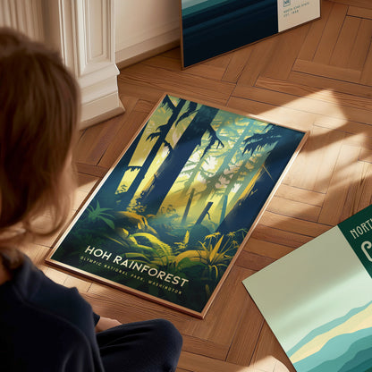 A person sits on a wooden floor, looking at a vibrant Hoh Rainforest poster featuring tall trees and lush greenery, with sunlight filtering through the forest canopy.