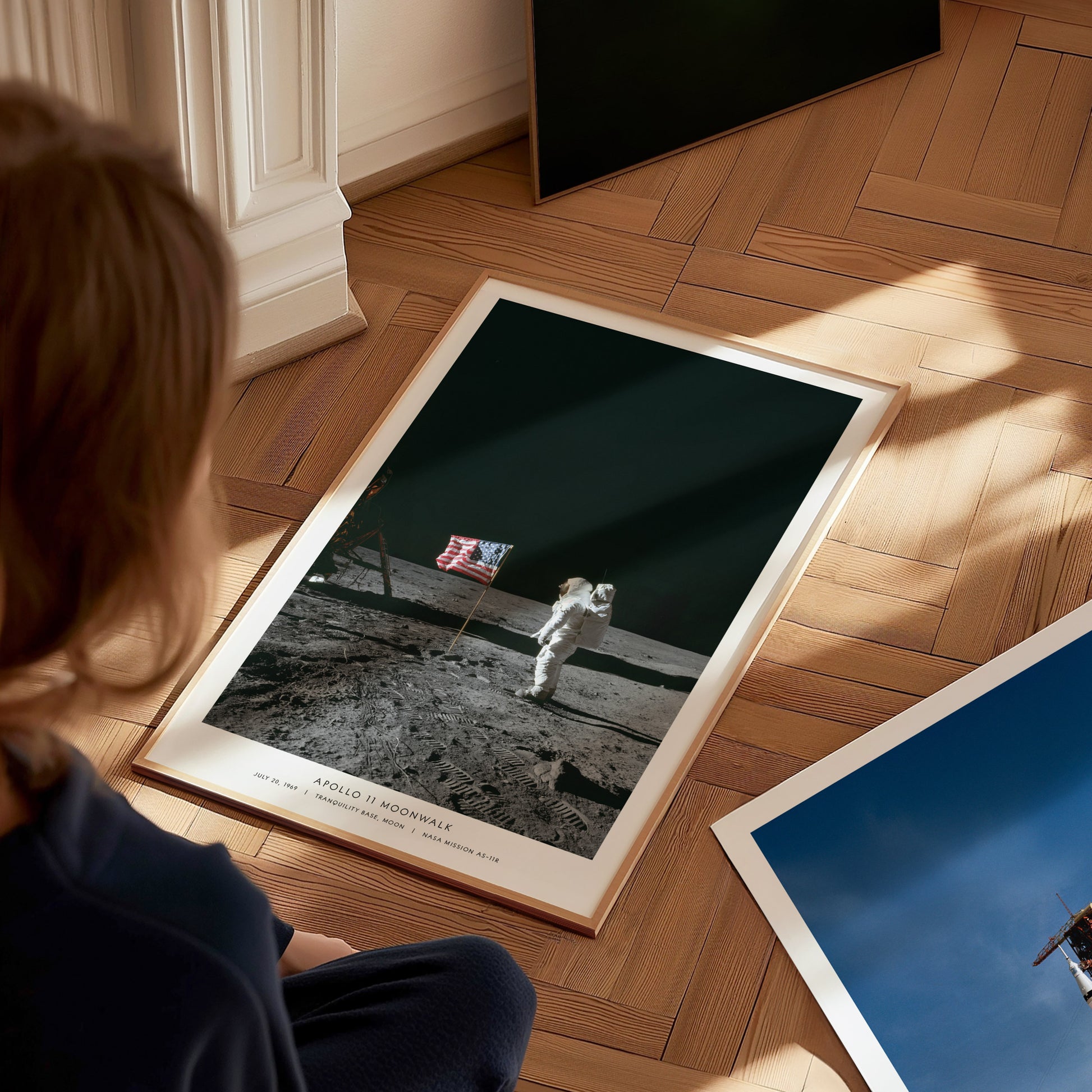 Person looking at a framed photograph of Apollo 11 moon landing print