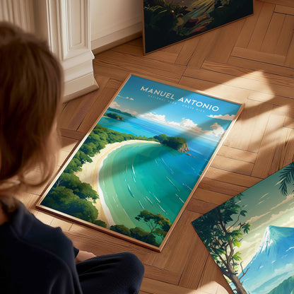 A person is sitting on a wooden floor, looking at a vibrant poster of Manuel Antonio National Park featuring turquoise waters, white sand, and lush greenery. Sunlight casts soft shadows.