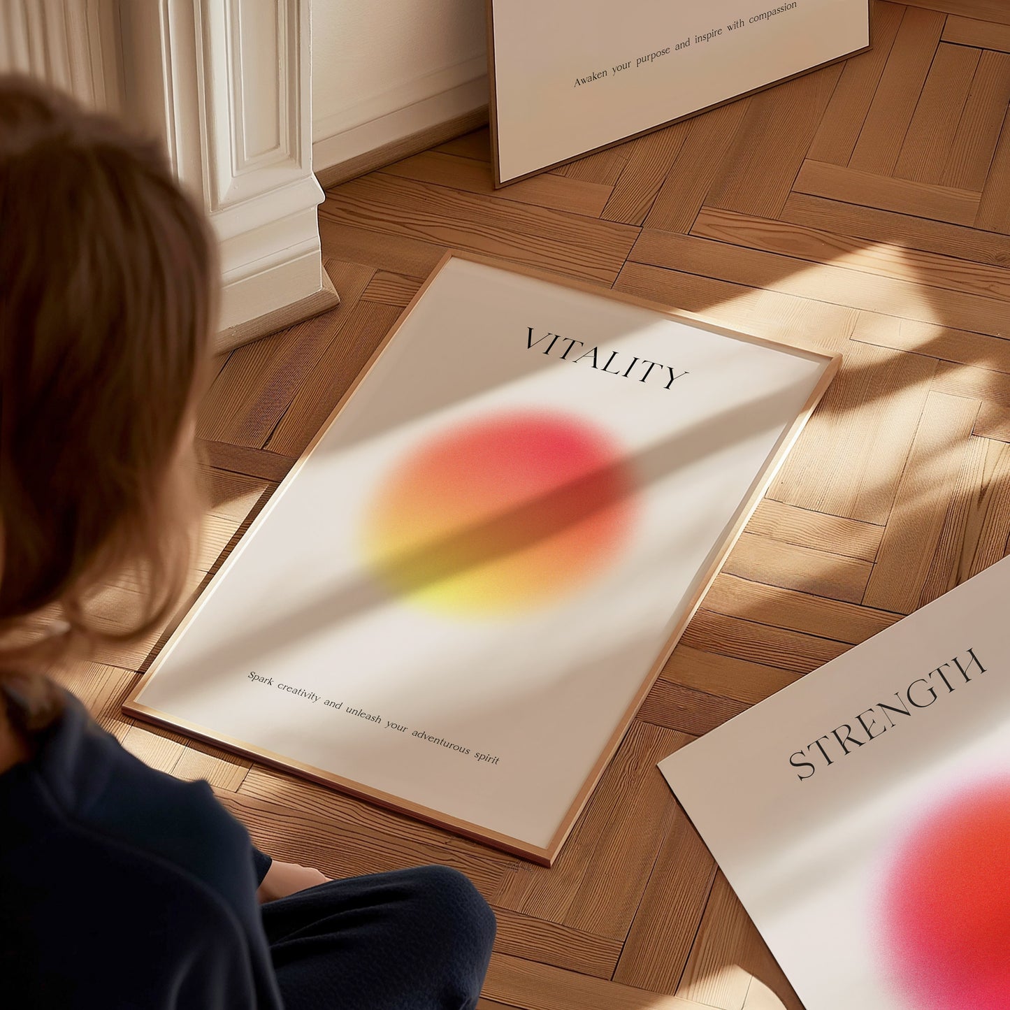 Person sitting on a wooden floor looking at a framed motivational poster titled 'Vitality'.