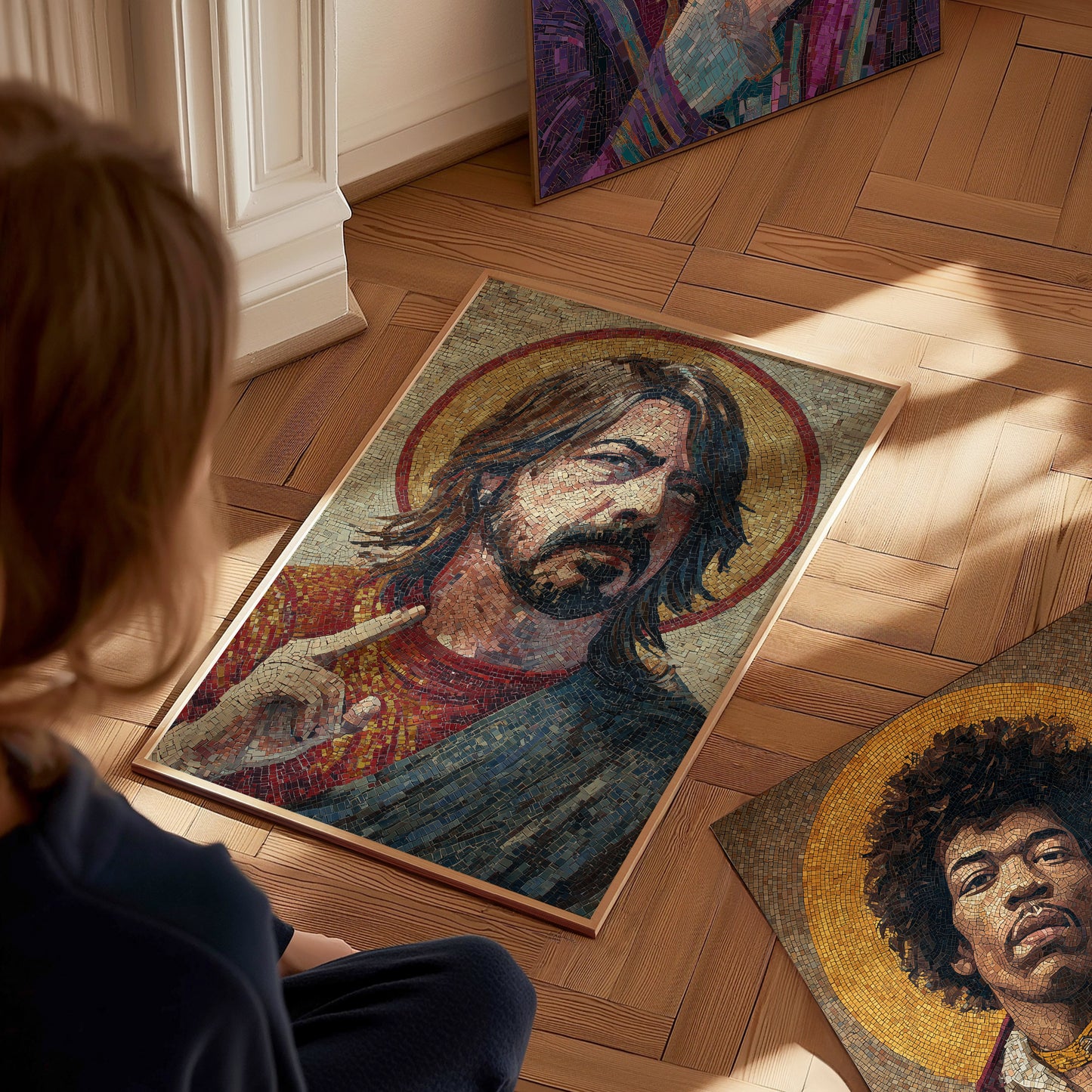 A person sits on a wooden floor, gazing at an intricate mosaic art piece depicting a male figure with long hair and a serene expression, framed by a golden halo.