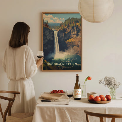 A woman in a white dress holds a glass of wine while admiring a framed Snoqualmie Falls poster. The table is set with fruits, wine, and a vase with flowers.