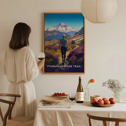 A woman in a white dress holds a glass of wine while admiring a Ptarmigan Ridge Trail poster. A dining table with fruits and a wine bottle is in the.