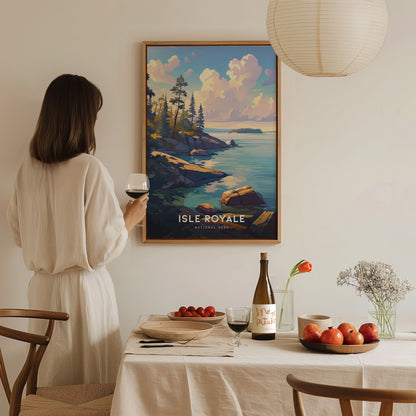 A woman in a white dress holds a glass of wine, admiring a framed Isle Royale National Park poster on the wall.