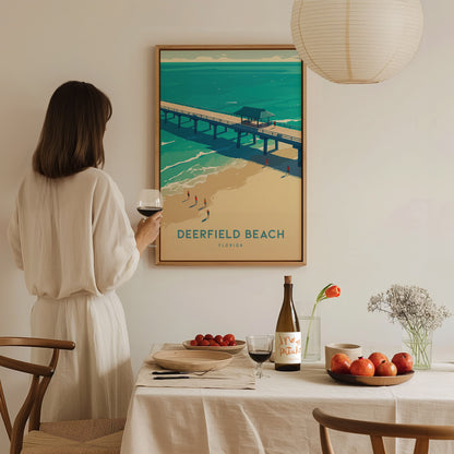 A woman in a white dress admires a Deerfield Beach poster on the wall. A dining table with wine, fruit, and flowers is set in the foreground.