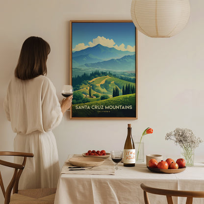 A woman in a white dress admires a Santa Cruz Mountains poster while holding a glass of red wine. The table features a bottle, fruit, and flowers.