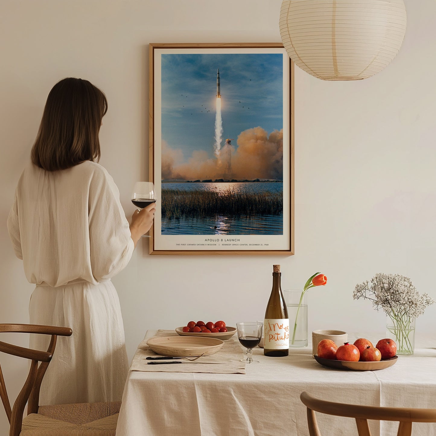Large format Apollo 8 launch poster centered above a sofa with soft natural lighting